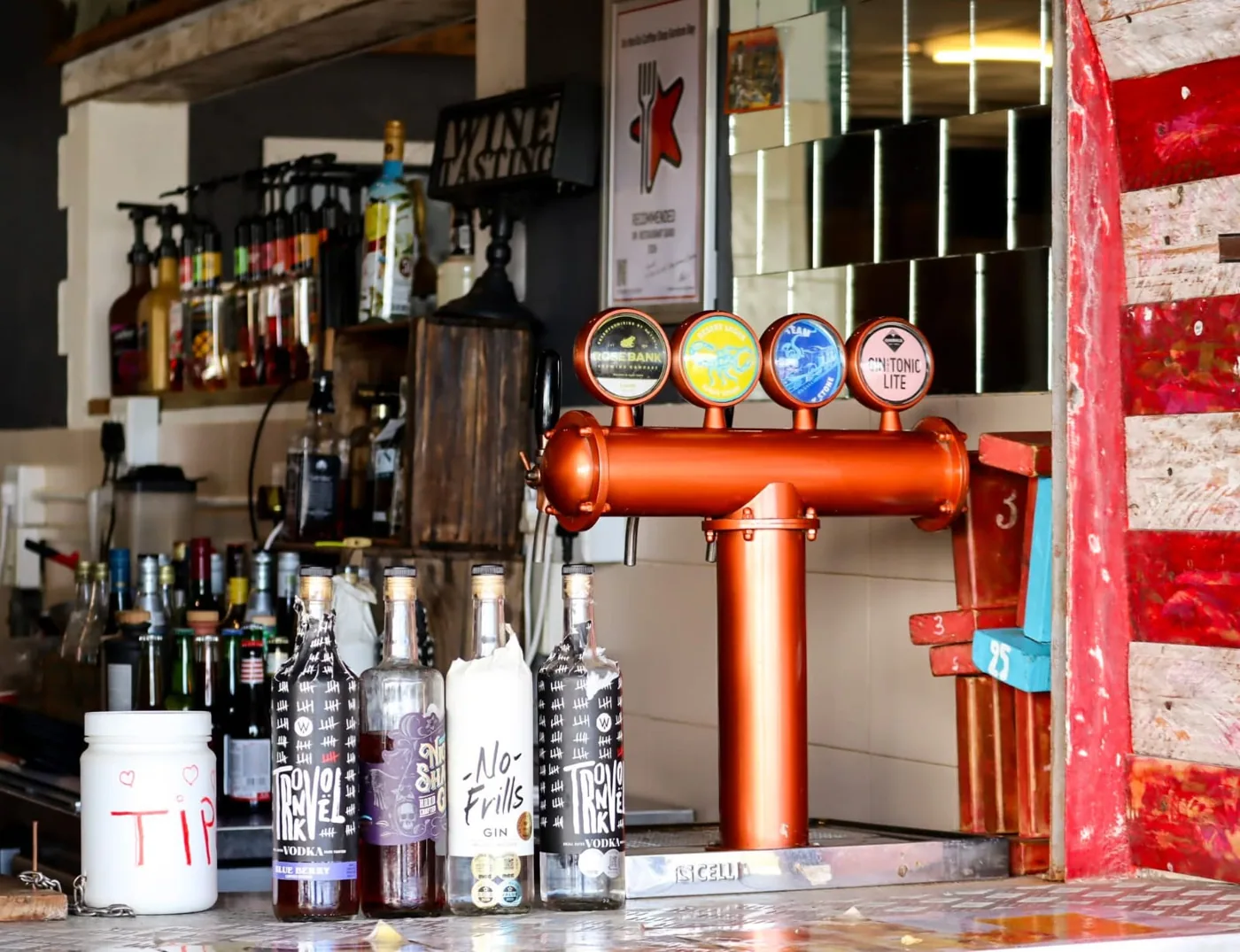 The bar at On The Go with craft beer taps and a row of spirits.